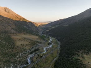 Aerial view, mountain stream Ala Archa flows through the Ala Archa valley, autumnal mountain