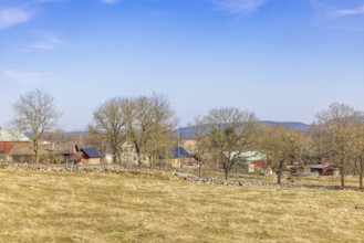 Landscape view at a small village med hus och lador on the Swedish countryside a sunny spring day,