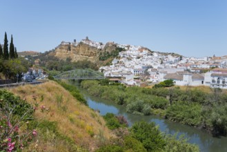 Small town with white houses on a hill, crossed by a river, surrounded by nature, Arcos de la