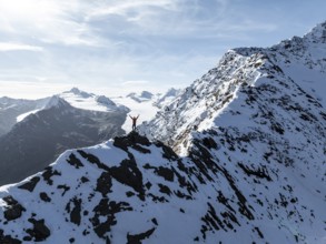 Mountaineer standing triumphantly on the snow-covered Ramoljoch under a clear sky in the Alps,