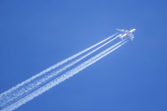 An Emirates Airbus A380-800 aircraft with registration number A6-EVN in flight with contrails over