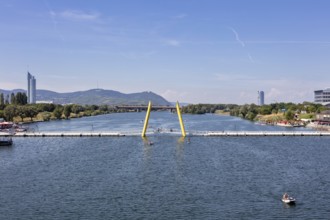 View of a river with bridge, surrounded by mountains and architecture, Vienna