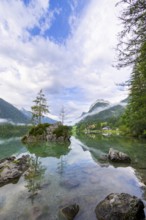 Hintersee with rocks and trees in the foreground, surrounded by mountains, cloudy sky, Ramsau,