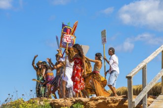 Colourfully dressed youths with musical instruments and banners form a love parade and promote the