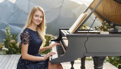 A young woman in a blue dress smilingly plays a black grand piano in a modern room, AI generated,