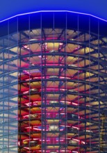 An illuminated car tower with new cars for delivery in the evening, Autostadt, Volkswagen AG,