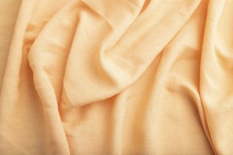 Fragment of orange linen tissue. Top view, natural textile background and texture. wave concept,