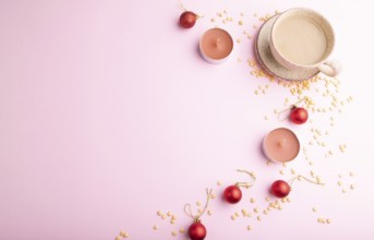 Christmas or New Year composition. Decorations, red balls, cup of coffee, on a pink paper