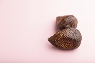 Salak or snake fruit on pink pastel background. Side view, copy space. Tropical, healthy food,