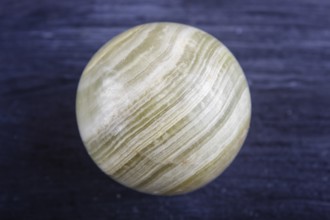 Green onyx sphere on a black background, close up