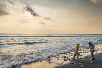 Muslim woman in the evening sun at Mangsit beach in Sengiggi, Islam, religion, headscarf, travel,