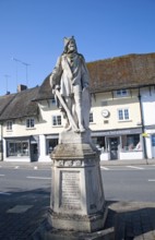 King Alfred the Great statue in the market place and thatched shop buildings village of Pewsey,