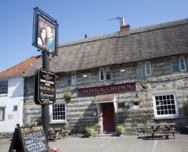 Rose and Crown pub at Tilshead, Wiltshire, England with pub sign painted of Prince William and his