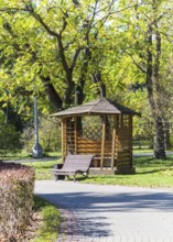 Gazebo and a bench under the trees in the park