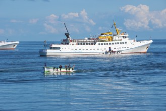 White ferry 'Fair Lady' during embarkation off the island of Heligoland, boats with people on open