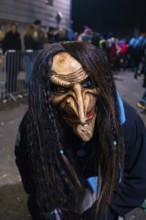 Close-up of a scary carnival mask with long hair at night, carnival, Schellbronn night parade,