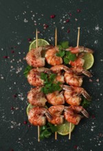 Shrimp kebab, with spices, lime, on wooden skewers, top view, no people