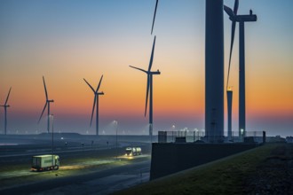 Lorry on the road from Euromax Terminal Rotterdam, ENECO wind farm on the dike around the port of