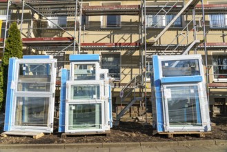 Energy-efficient refurbishment of residential buildings, older apartment block is scaffolded, gets