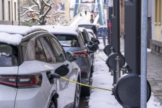 Winter in the city, electric cars charging at charging stations in the city centre of Frankfurt,