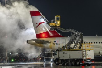 Winter at Frankfurt Main Airport, FRA, Austrian aircraft being de-iced by de-icing vehicles, Hesse,