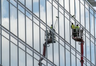 Window cleaner, building maintenance, facade cleaning, on a cherry picker, in Düsseldorf, North