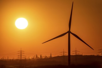 Wind turbine of the Emschergenossenschaft, view to the west, in Essen, sunset, behind the blast