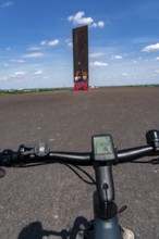 Cycling in the Ruhr area, on the Schurenbach slag heap, Bramme landmark for the Ruhr area by artist