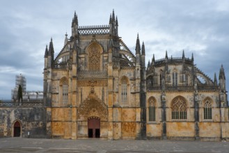 Large Gothic cathedral with impressive façade and pointed towers under a cloudy sky, monastery,