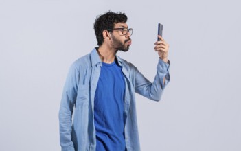 Funny Man blowing kisses on the cell phone isolated. young man taking selfie and blowing kisses on