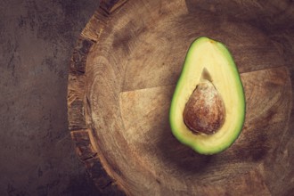 Fresh, sliced avocado, in a wooden plate, top view, food background, concept, food styling