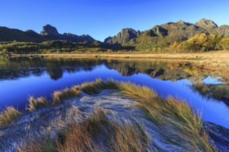 Mountains reflected in lake, morning light, sunny, autumn, Vesteralen, Norway, Europe