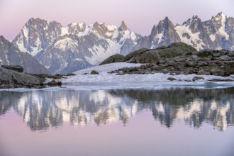 Evening mood with pink evening sky, mountain landscape at sunset, water reflection in Lac Blanc,