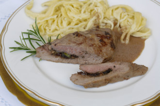 Swabian cuisine, lamb stuffed with prunes, rosemary, herbs, fillets arranged on plates,