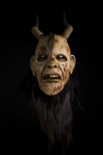 Frontal view of a devilish mask with horns and a terrifying facial expression