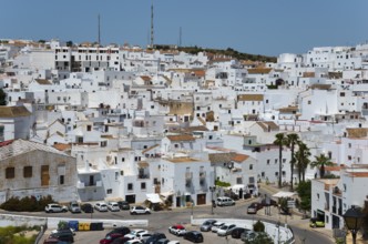 Panorama of a white town with narrow streets, parked cars and hilly surroundings, New Town, Vejer