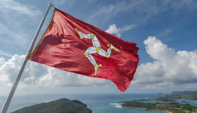 The flag of the Isle of Man, Great Britain, flutters in the wind