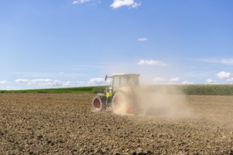 Symbolic image, global warming, dry soil, dust, farmer tilling a field, tractor, ploughing, clouds,