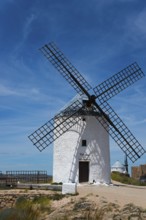 White windmill with wooden wings in a field under a clear blue sky, Consuegra, Toledo, Castilla-La