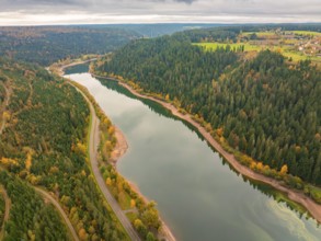 Panoramic view of a river in a wooded region with colourful autumn landscape and roads,