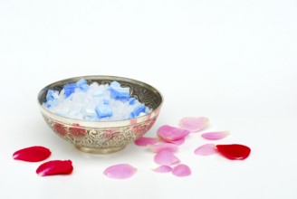 Bath salt in a bowl, rose petals