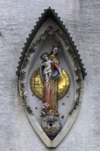 Sculpture of the Mother of God, Mary with the Child Jesus on a residential building facade,