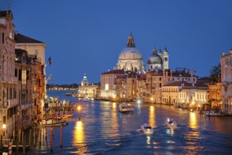 View of Venice Grand Canal with boats and Santa Maria della Salute church in the evening from Ponte