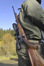 Hunter with shotgun and scope in the Ardennes, Belgium, Europe