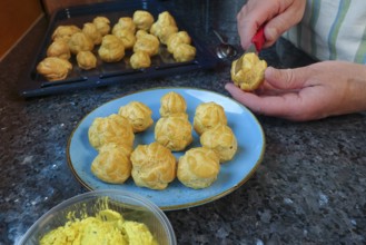 Swabian cuisine, preparing mini cream puffs, slicing eclairs, profiteroles, piping pastries, oven