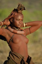 Young Himba woman doing her hair, Ombombo, Kaokoland, Kunene, Namibia, Africa