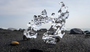 Ice, piece of ice on black sand beach, on black lava beach Diamond Beach, Southeast Iceland,