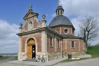 Cyclists leaving the chapel of Our Lady of the Old Mountain on the Muur van Geraardsbergen,