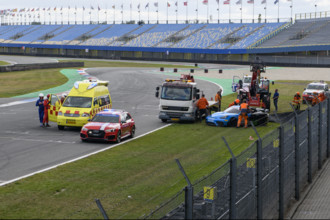 View of the scene after a serious racing accident, left yellow ambulance, in front red medical car