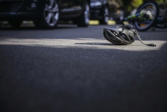 Symbol photo on the subject of bicycle accidents (posed scene) . A broken bicycle helmet lies next